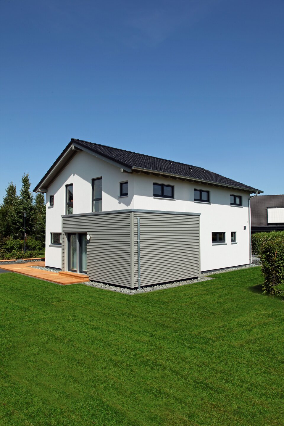 Außenansicht des FingerHaus Musterhauses NEO 300 in Hannover mit moderner weiß-grauer Fassade, Satteldach und bodentiefen Fenstern.