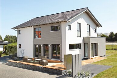 Außenansicht des FingerHaus Musterhauses NEO 300 in Hannover mit moderner Fassade, Satteldach und großzügiger Terrasse.