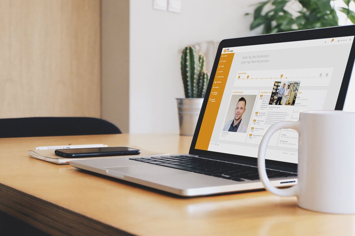 Laptop mit geöffnetem FingerHaus-Serviceportal auf einem Schreibtisch; die Bauherren-Oberfläche zeigt Projektübersicht, Dokumente und Ansprechpartner.