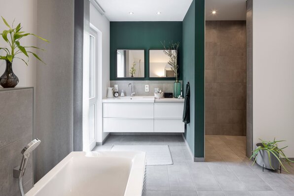 Modernes Badezimmer im frei geplanten FingerHaus mit Doppelwaschtisch, großer Dusche und Badewanne.