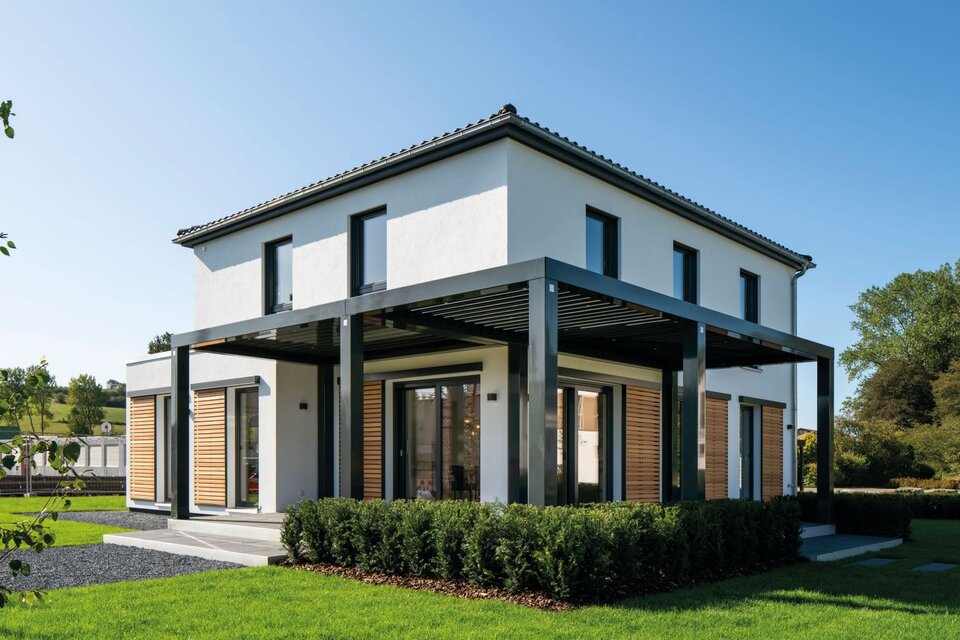 Modernes zweigeschossiges Musterhaus MEDLEY 300 B in Frankenberg mit Flachdach-Überdachung der Terrasse und großen Fensterflächen.
