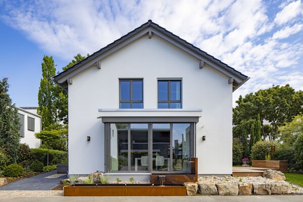 Frontansicht des FingerHaus MEDLEY Musterhauses in Mannheim mit großem Wintergarten, klarer Linienführung und moderner Gartenanlage.