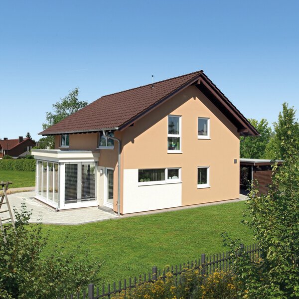 Außenaufnahme des MEDLEY 310 im Musterhaus Erfurt mit Garten und Wintergartenanbau.