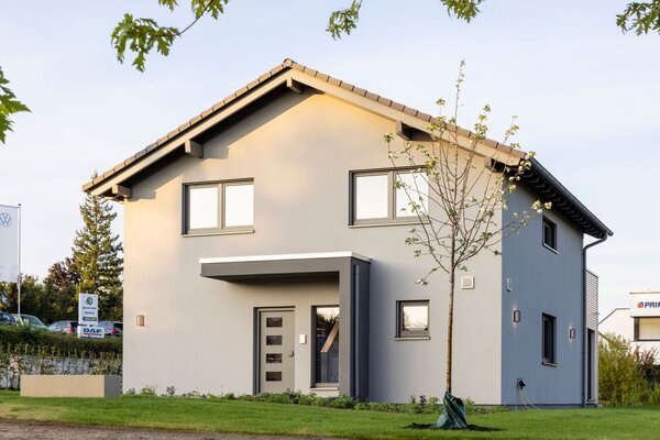 Eingangsansicht des FingerHaus ARTIS 300 Musterhauses Würzburg mit grauer Putzfassade, moderner Haustür und Satteldach.