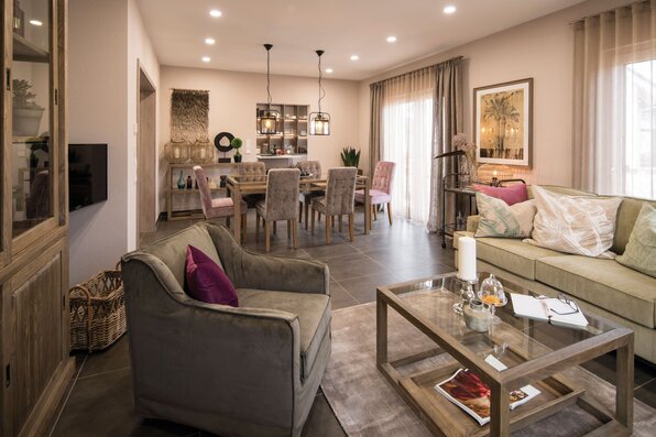 Wohn- und Essbereich im Musterhaus UNO 2.0 in Leipzig mit gemütlicher Einrichtung, großem Esstisch und stilvollem Lichtkonzept.