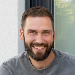Familie mit Kind sitzt auf den Stufen vor dem SENTO 403 und lächelt in die Kamera