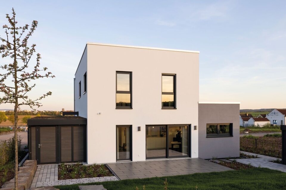 Musterhaus TALO in Fulda mit moderner kubischer Architektur, Flachdach und klaren Linien, aufgenommen am Abend.