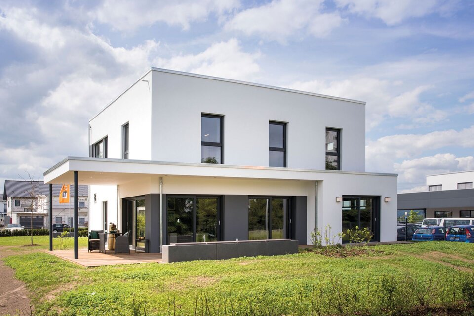 Musterhaus MAXIM in Gießen bei Tag, moderne Architektur mit Flachdach, klaren Linien und überdachter Terrasse.