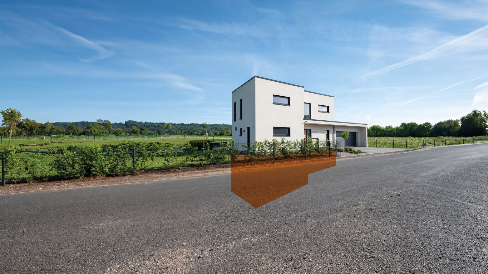 Modernes Fertighaus von FingerHaus mit heller, kubischer Fassade und Flachdach, dargestellt mit transparent markiertem Kellerbereich in orange, gelegen an einer Straße mit freiem Blick ins Grüne.