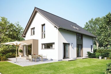 FingerHaus NEO 300 – modernes Einfamilienhaus mit dunklem Satteldach, heller Putzfassade und großen Fenstern. Im Garten befinden sich eine Terrasse mit Esstisch und Sonnenschirm, gepflegter Rasen und blühende Beete.