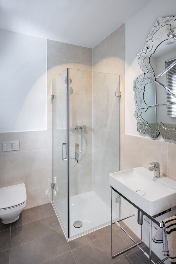 Modernes Gäste-Bad im MEDLEY Musterhaus Mannheim mit Glasdusche, WC und stilvollem Waschtisch.
