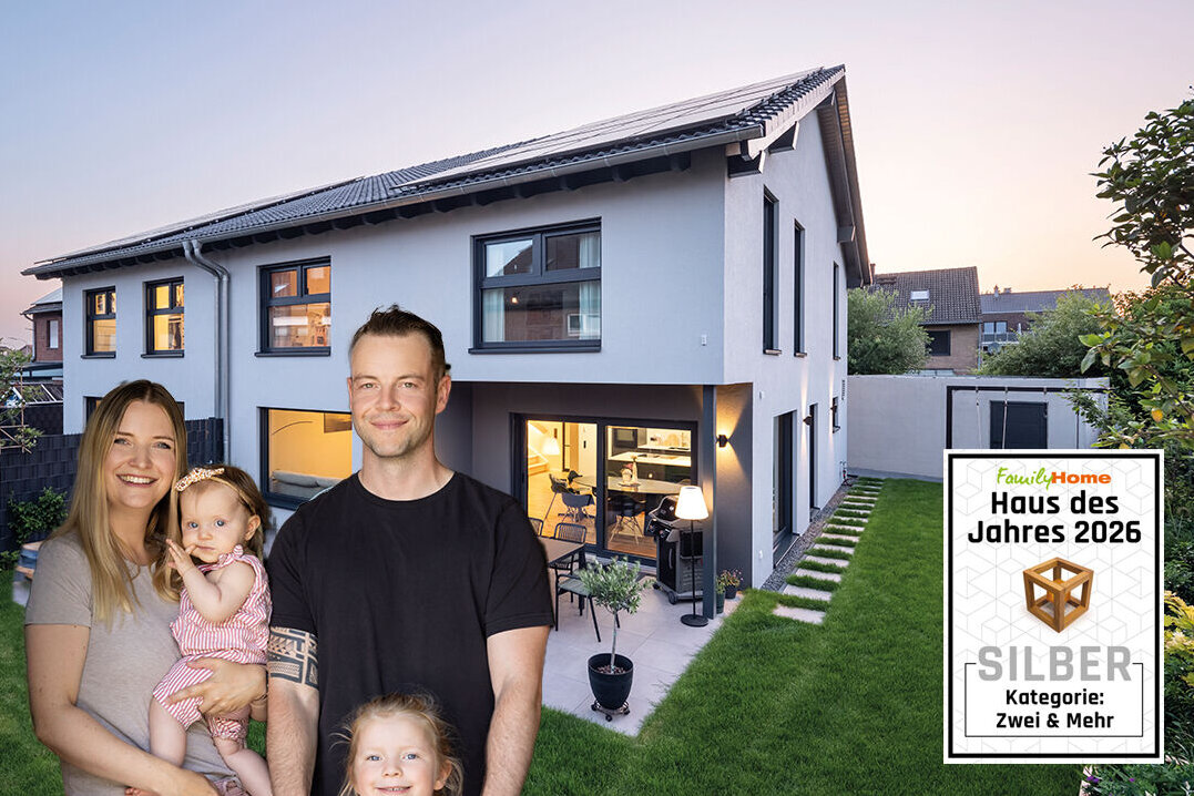 Familie mit zwei Kindern vor ihrem modernen FingerHaus DUO 258 mit Garten, ausgezeichnet als „Haus des Jahres 2026“ in Silber in der Kategorie „Zwei & Mehr“.