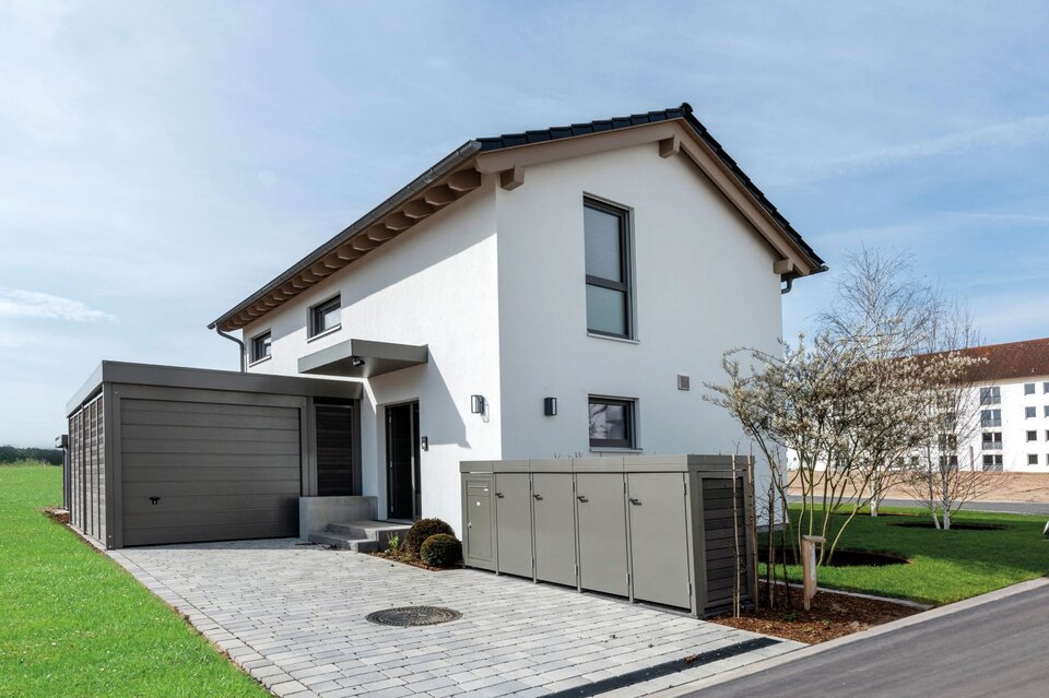 Musterhaus TALO von FingerHaus in Babenhausen mit angebauter Garage, gepflasterter Einfahrt und gepflegtem Vorgarten.