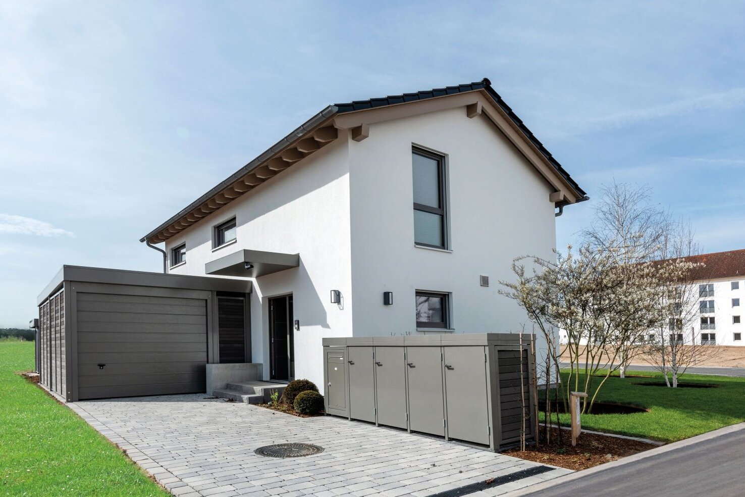 Musterhaus TALO von FingerHaus in Babenhausen mit angebauter Garage, gepflasterter Einfahrt und gepflegtem Vorgarten.