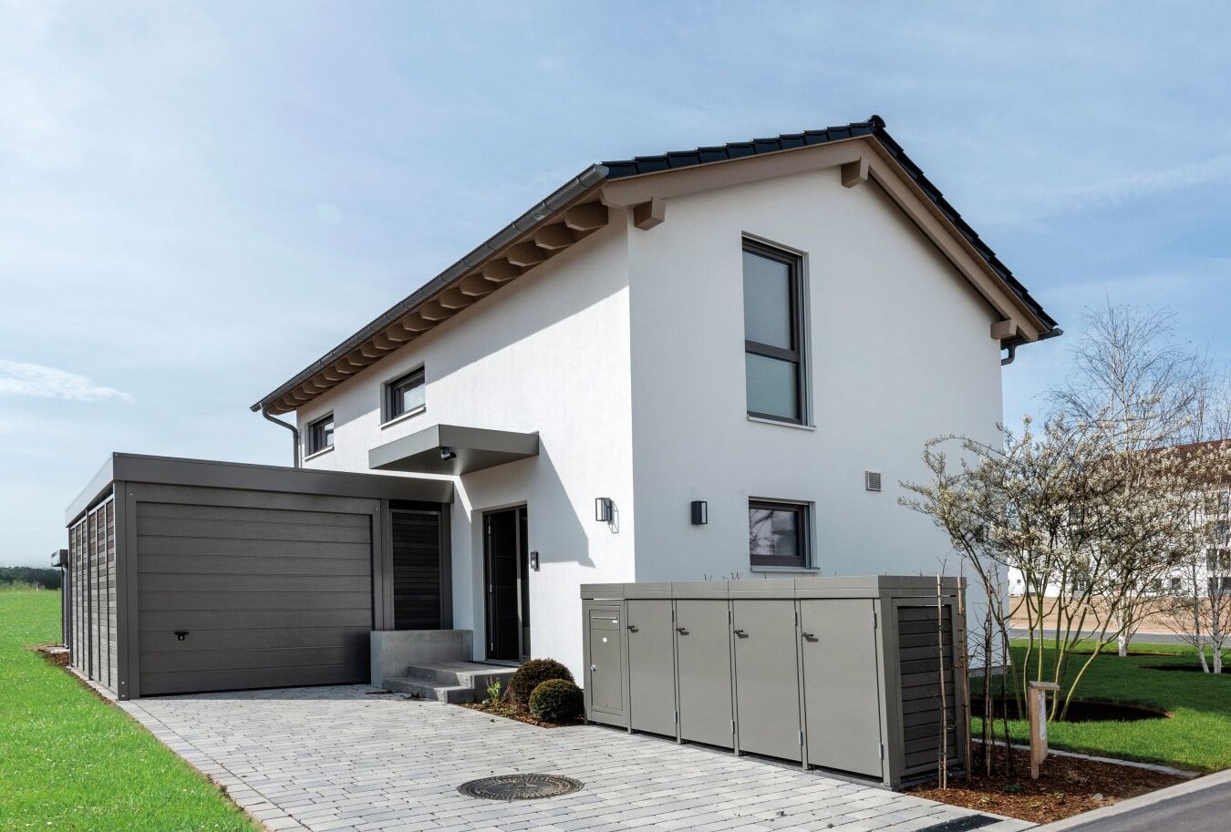 Musterhaus TALO von FingerHaus in Babenhausen mit angebauter Garage, gepflasterter Einfahrt und gepflegtem Vorgarten.