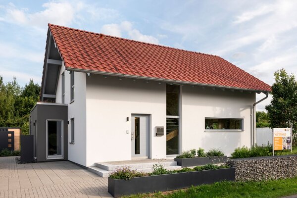 Frei geplantes FingerHaus Musterhaus in Marburg mit rotem Satteldach, moderner Fassade und einladendem Eingangsbereich.