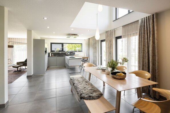 Offene Küche mit Essbereich im FingerHaus NEO 300 Musterhaus Hannover, mit modernem Esstisch, heller Einrichtung und viel Tageslicht.