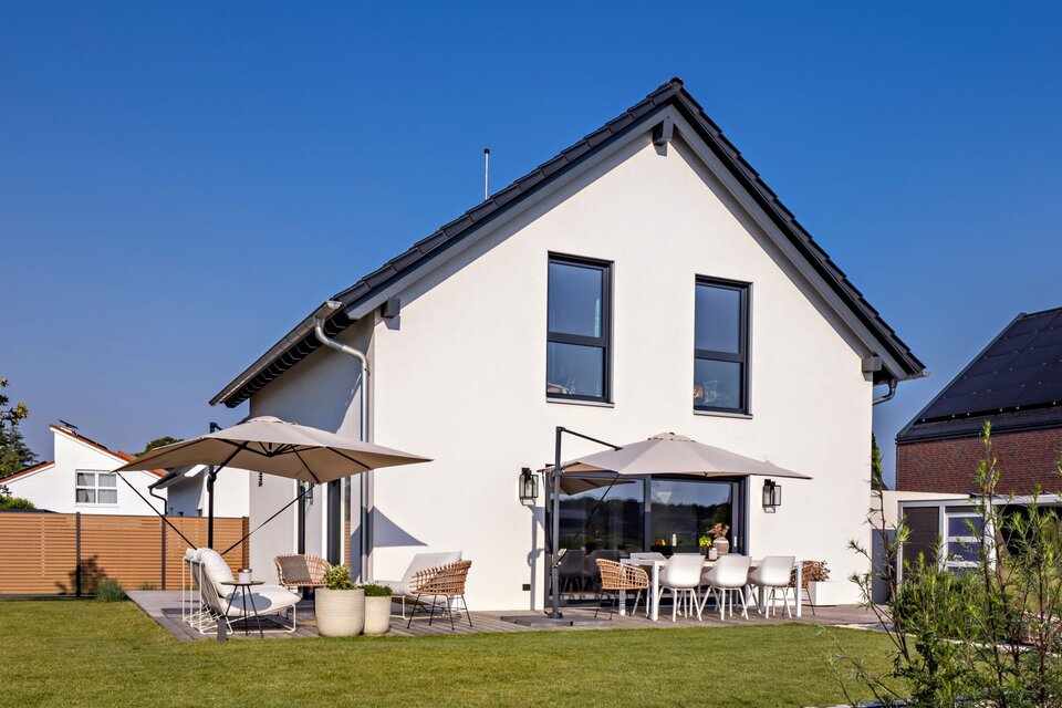 Frei geplantes FingerHaus mit moderner Gartengestaltung, Terrasse und Sonnenschirmen.