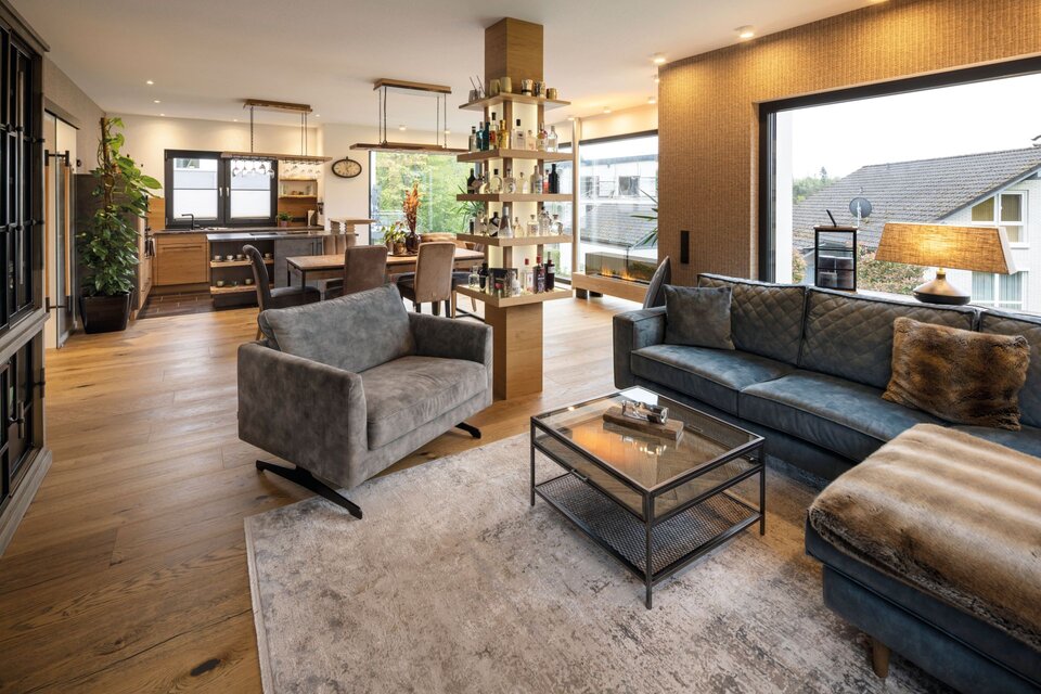 Offener Wohnbereich eines frei geplanten FingerHauses mit moderner Küche, großem Essbereich und gemütlicher Sitzecke.