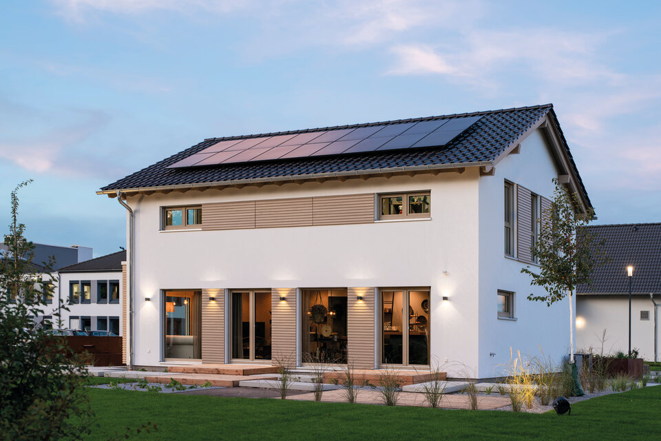 FingerHaus SENTO 500 Musterhaus in Frankenberg mit moderner weißer Fassade, Holz-Elementen, großem Satteldach mit Solaranlage und weitläufigem Garten.