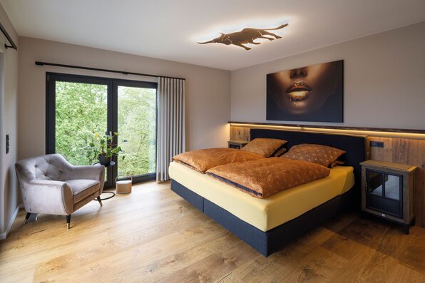 Frei geplantes FingerHaus mit modernem Schlafzimmer, großen Fenstern und eleganter Einrichtung.