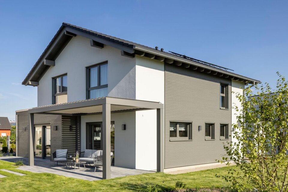 FingerHaus ARTIS 300 Musterhaus Nürnberg mit überdachter Terrasse, moderner Fassade in Weiß und Grau sowie großem Gartenbereich.