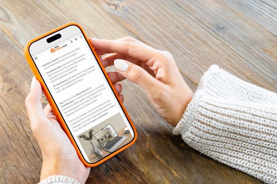 Person hält ein Smartphone mit dem FingerHaus Serviceportal in den Händen. Auf dem Display sind Informationen zur Bemusterung dargestellt.