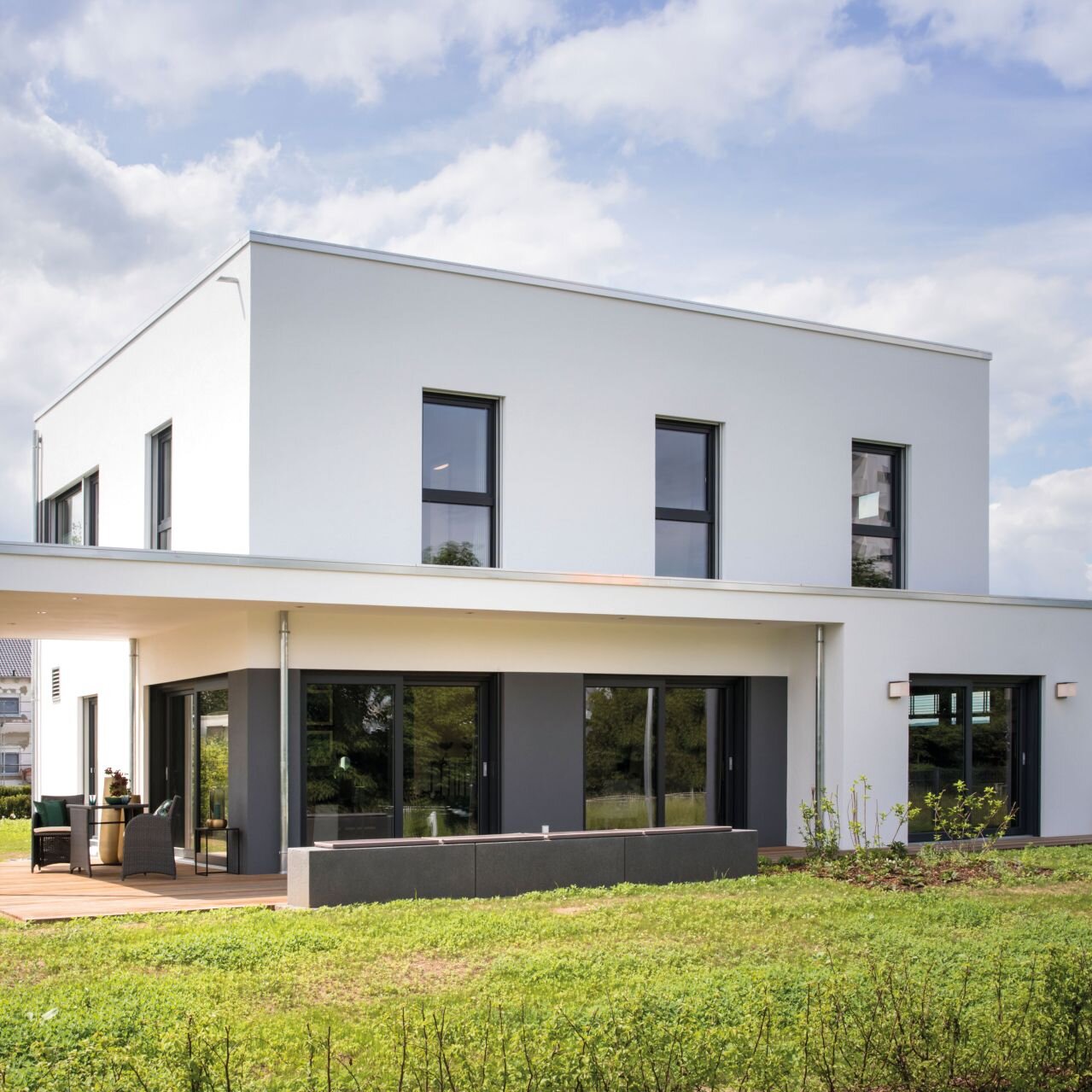 Musterhaus ALTERO in Gießen bei Tag, moderne Architektur mit Flachdach, klaren Linien und überdachter Terrasse.