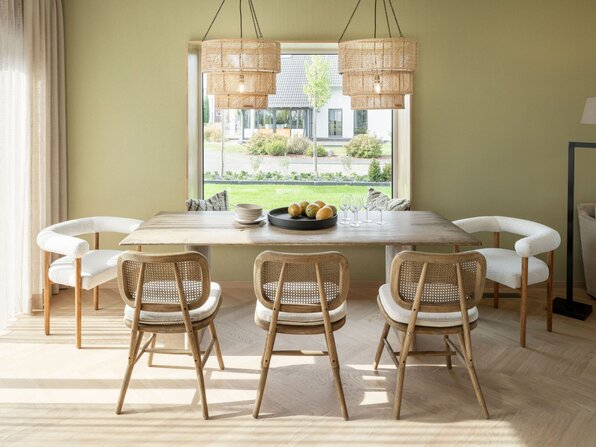 Essbereich im Musterhaus JUNO 300 in Mülheim-Kärlich mit Holztisch, modernen Stühlen, großen Fenstern und natürlichen Materialien.