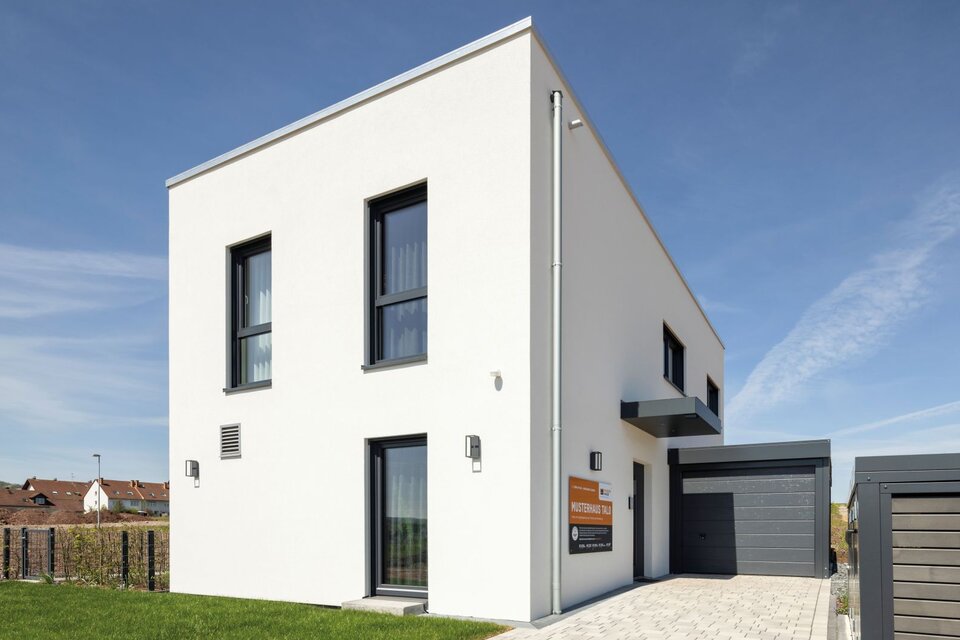 Eingangsbereich des Musterhauses TALO in Fulda mit moderner Kubusarchitektur, Garage und klarer Linienführung.