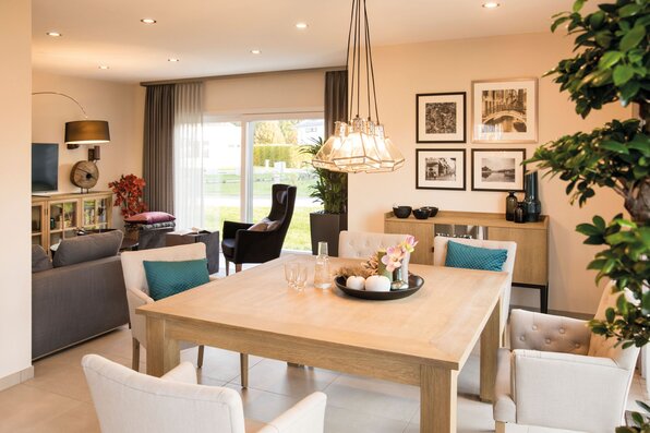 Essbereich im FingerHaus NEO Musterhaus Günzburg mit großem Holztisch, stilvollen Polsterstühlen und eleganter Pendelleuchte.