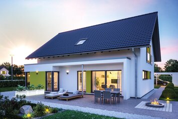 FingerHaus VIO 500 S130 mit Satteldach, Erker und großer Terrasse im Abendlicht