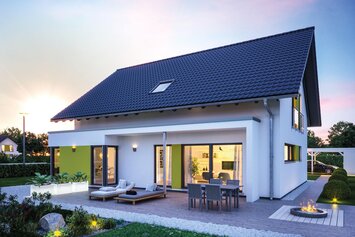 FingerHaus VIO 500 S130 mit Satteldach, Erker und großer Terrasse im Abendlicht