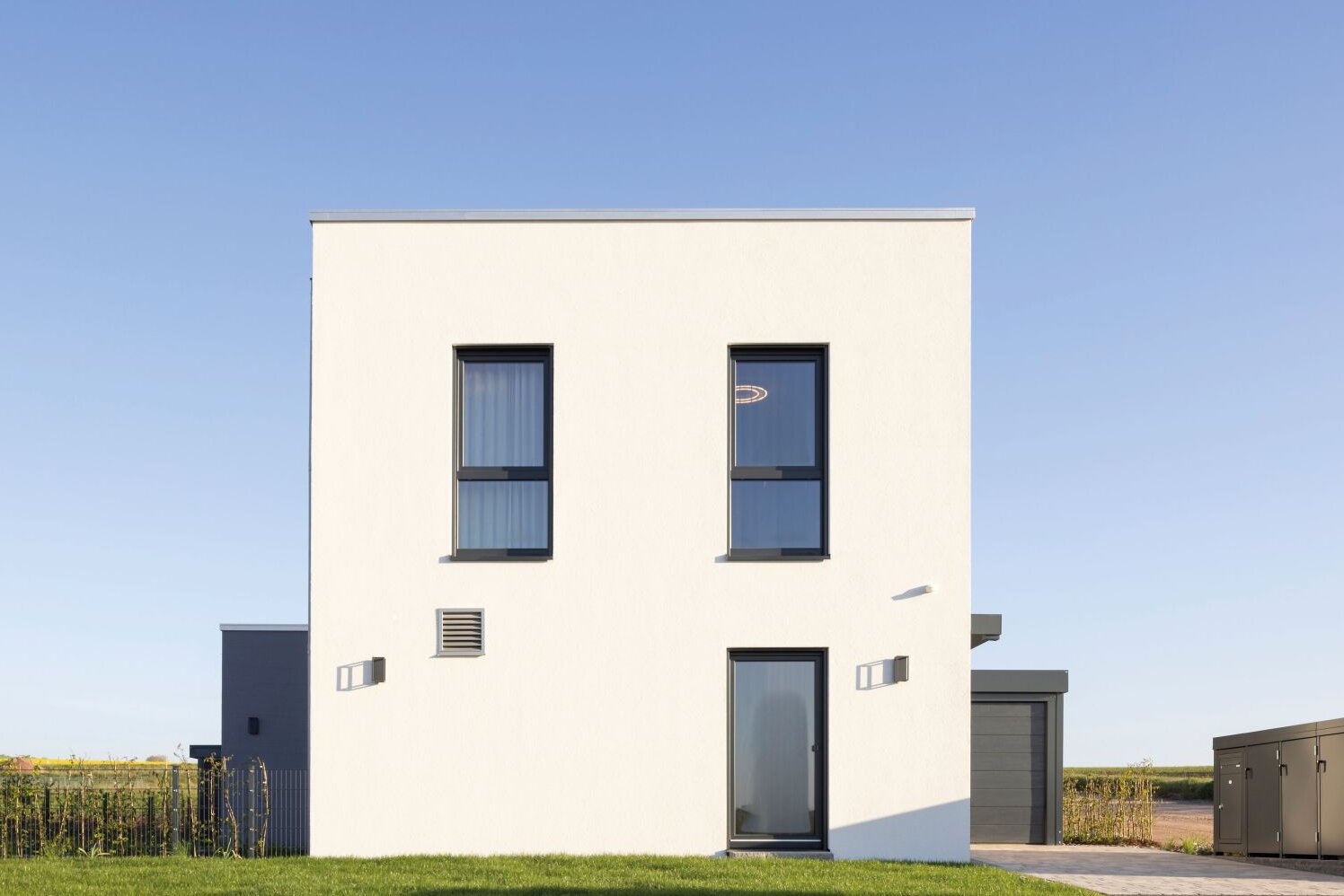 Frontansicht des Musterhauses TALO in Fulda – moderner Kubusbau mit klarer Architektur.