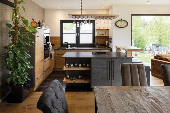 Frei geplantes FingerHaus mit moderner Küche, Kücheninsel und stilvollen Holz- und Steinelementen.