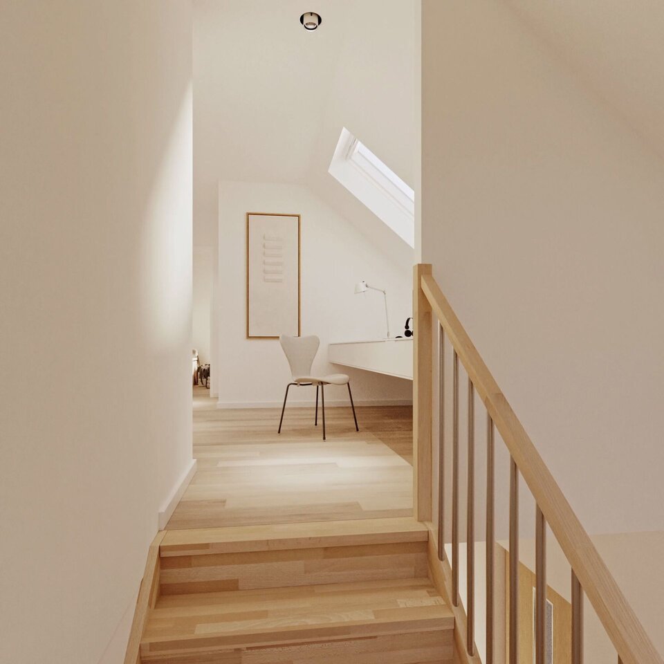 Heller Treppenaufgang mit Holzstufen, Oberlicht und kleinem Arbeitsbereich unter dem Dach.