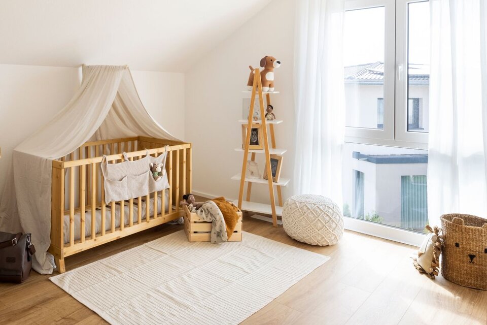 Kinderzimmer mit Holzmöbeln, Baldachin und großem Fenster. Heller Teppich und weiche Farben schaffen eine freundliche Atmosphäre.