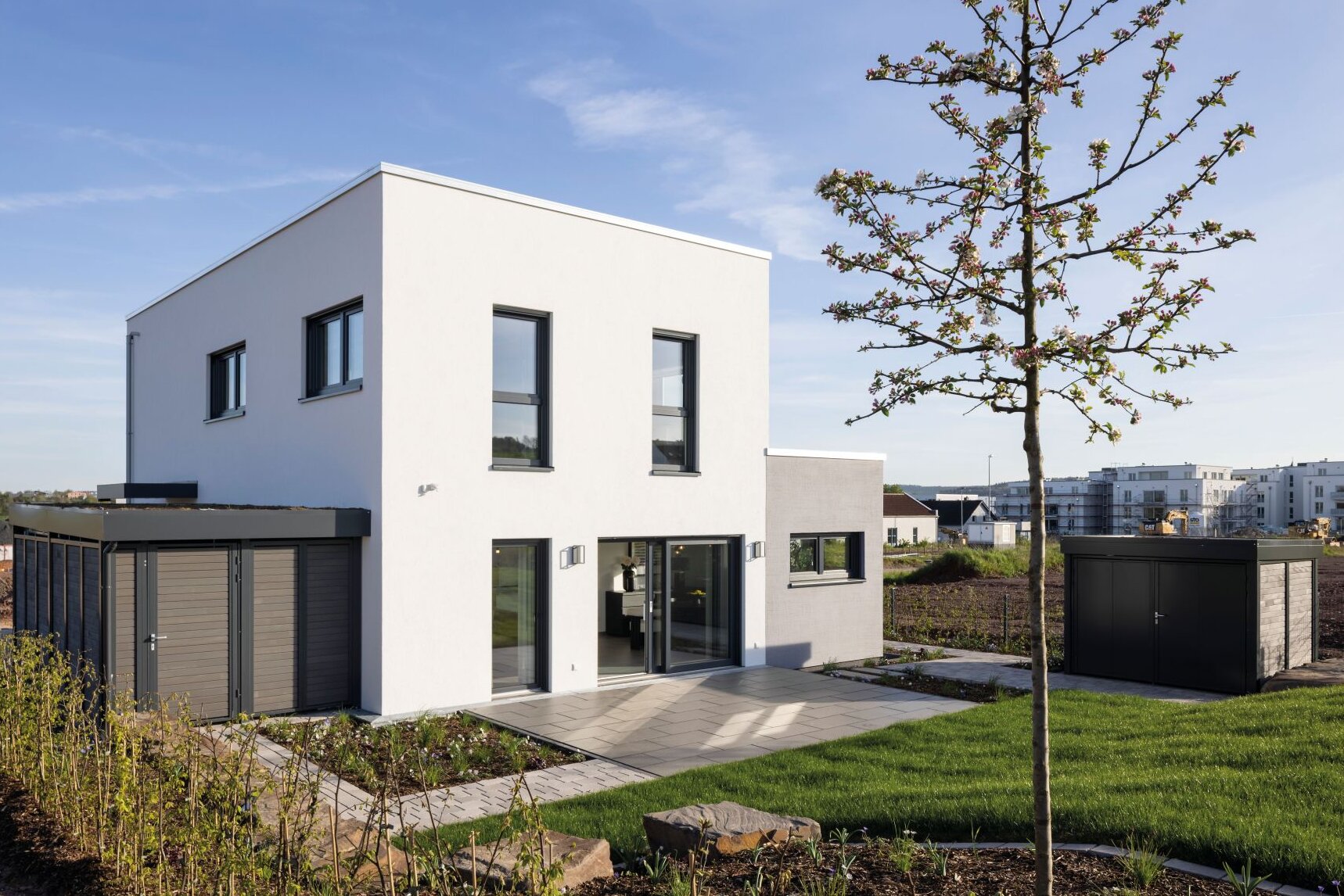 Modernes Musterhaus TALO Fulda mit klarer Kubusarchitektur, Garten und Terrasse.