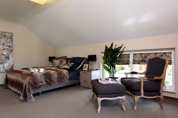 Schlafzimmer im MEDLEY 310, Musterhaus Erfurt, mit Doppelbett und Sitzecke.