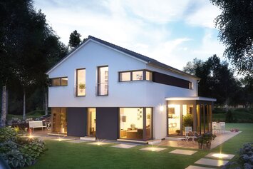 FingerHaus MEDLEY 410 – modernes zweigeschossiges Einfamilienhaus mit Satteldach, weiß-grauer Fassade und großen Fenstern in Abendstimmung. Innen- und Außenbeleuchtung schaffen eine warme Atmosphäre, im Garten sind Terrasse, Rasen und Steinweg sichtbar.