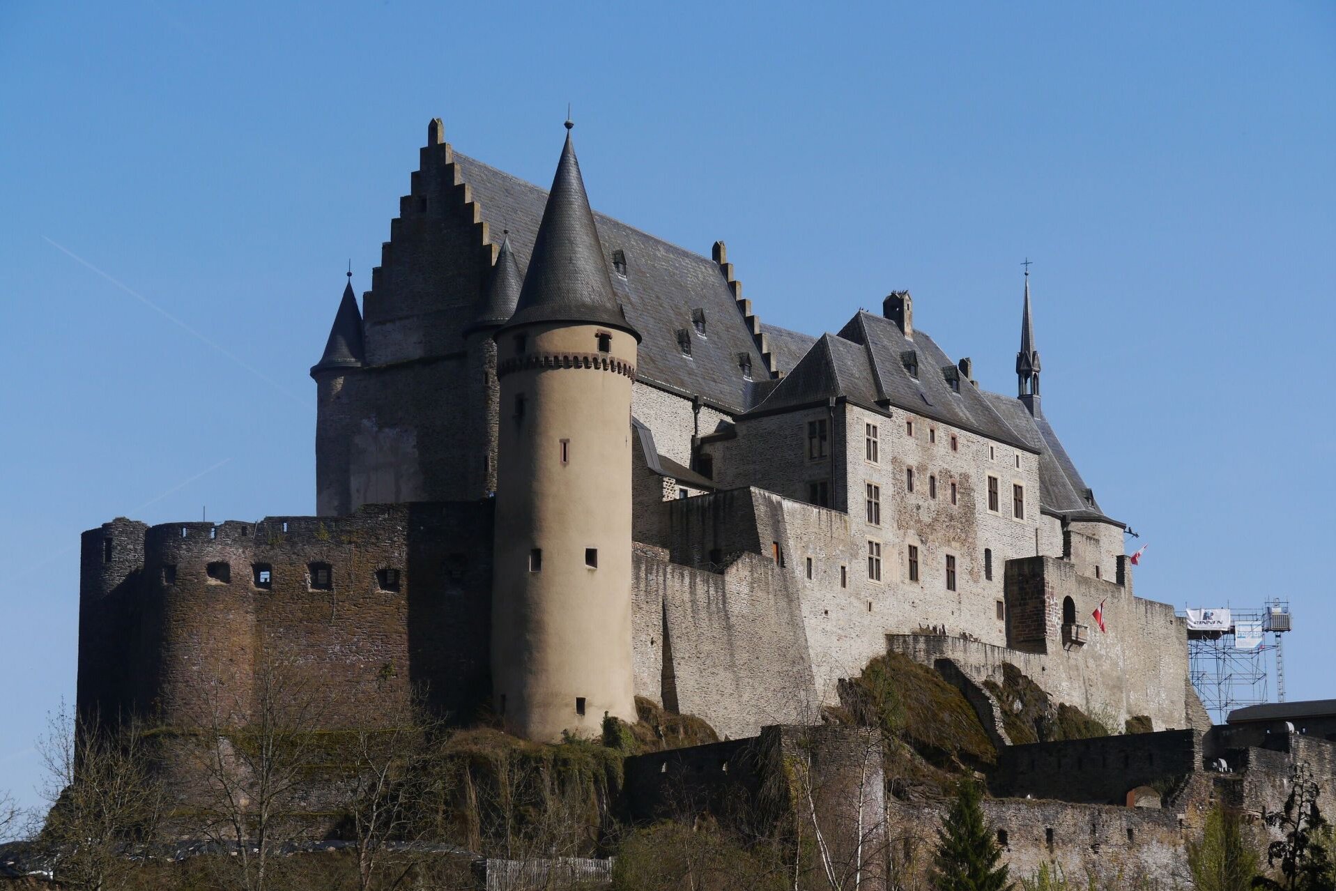 Burg Vianden mit mächtigen Festungsmauern, Rundtürmen und steilen Schieferdächern auf einem Felsen.