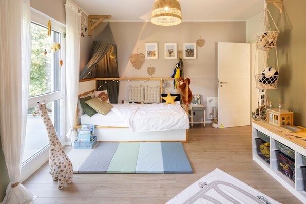 Modernes Kinderzimmer in einem frei geplanten FingerHaus mit spielerischer Einrichtung, gemütlichem Bett und großen Fenstern für viel Tageslicht.