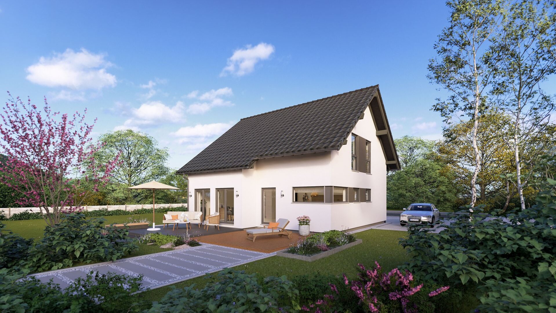 Modernes FingerHaus Fertighaus mit Satteldach, großen Fenstern und Terrasse mit Gartenmöbeln in grüner Umgebung