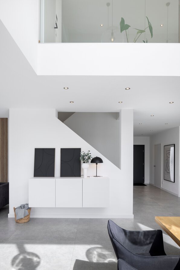 Lichtdurchfluteter Wohnbereich mit Galerie, modernen Möbeln und klarer Linienführung in einem frei geplanten FingerHaus.