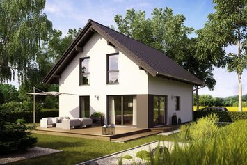 Fertighaus FingerHaus MEDLEY 102 A S100 mit heller Fassade, dunklem Satteldach und Holzterrasse mit Sitzmöbeln im sonnigen Garten, umgeben von Pflanzen und Bäumen.