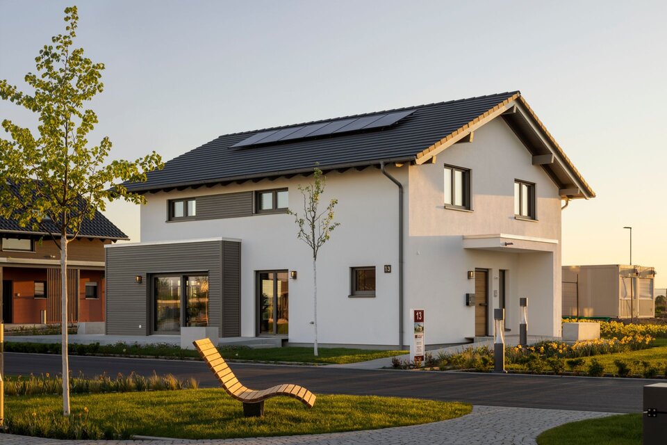 FingerHaus ARTIS 400 Musterhaus im Schwarzwald mit Satteldach, Photovoltaikanlage, weißer Fassade und modernen Holz-Elementen, umgeben von gepflegter Außenanlage.