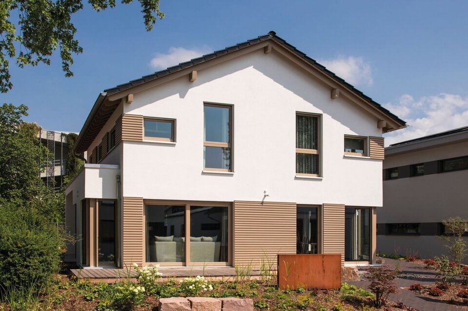 Straßenansicht des Musterhauses MEDLEY in Fellbach mit moderner Holzfassade, klarer Linienführung und großer Fensterfront.