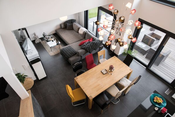 Offener Wohn- und Essbereich mit hoher Galerie, großer Fensterfront und moderner Einrichtung in einem FingerHaus.