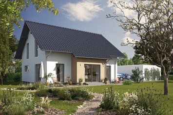 Fertighaus FingerHaus JUNO 200 mit heller Fassade, dunklem Satteldach und Gartenweg aus Kies, umgeben von blühenden Pflanzen und Rasen im Sonnenschein.