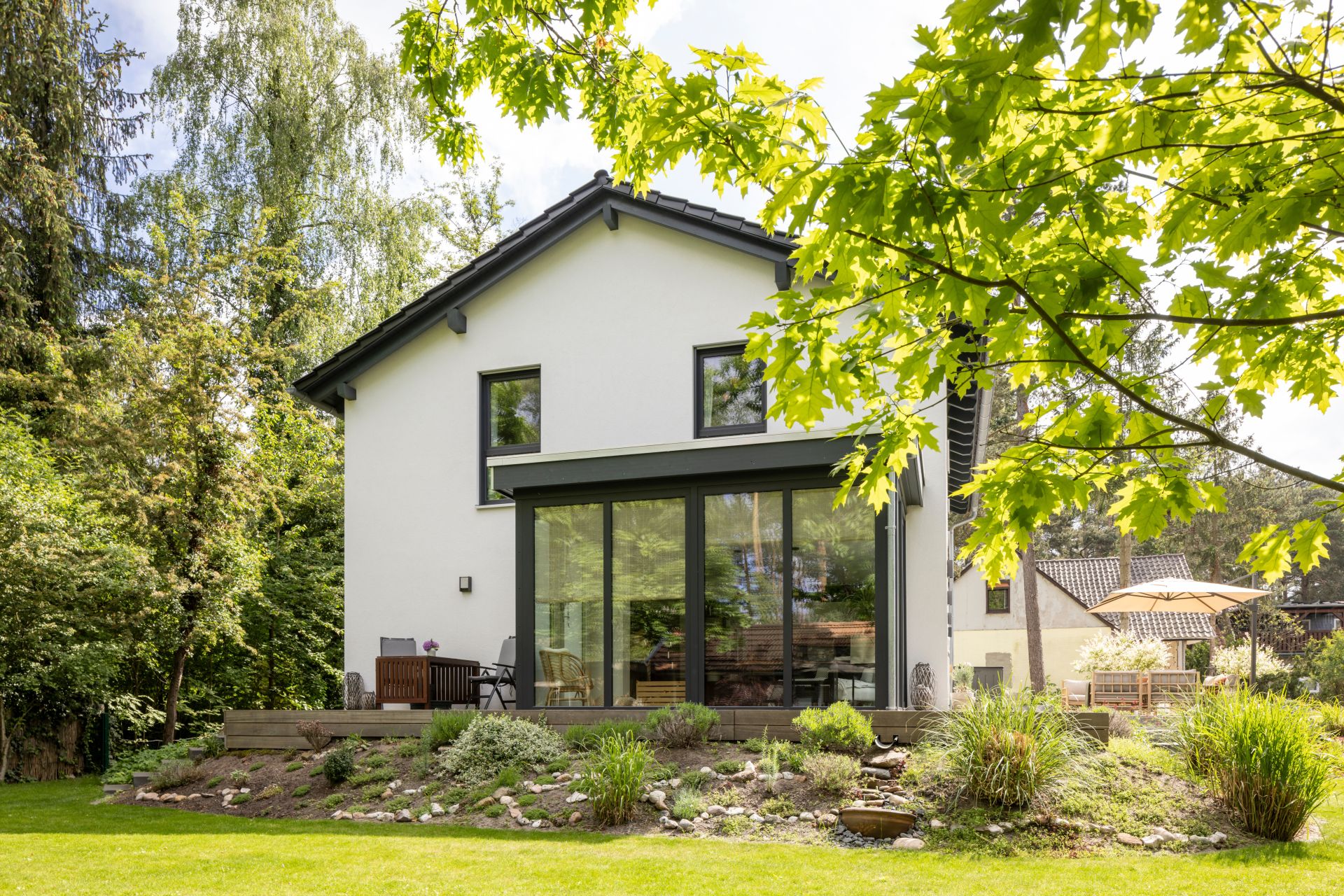 Frei geplantes FingerHaus mit großzügiger Glasfront und Blick auf den gepflegten Garten.